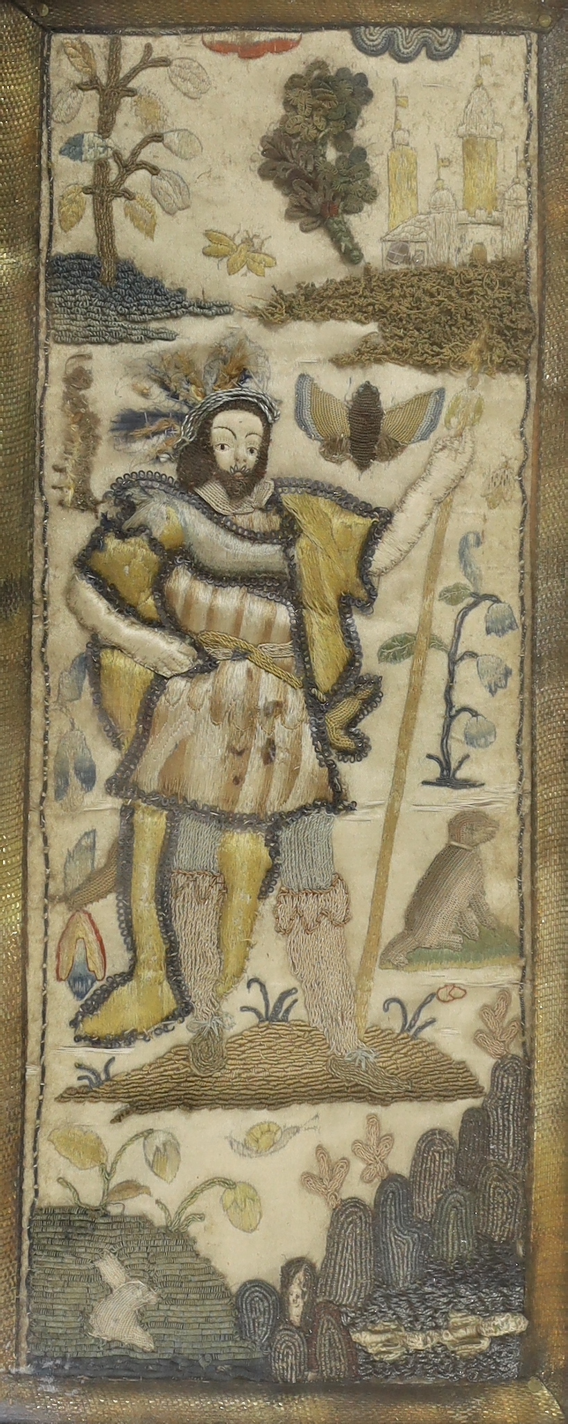 A framed 17th century stumpwork embroidery panel, embroidered with a central figure of a nobleman or king, possibly Henry VIII, holding a staff, wearing a cloth of gold with his dog in the grounds of a castle (possibly N
